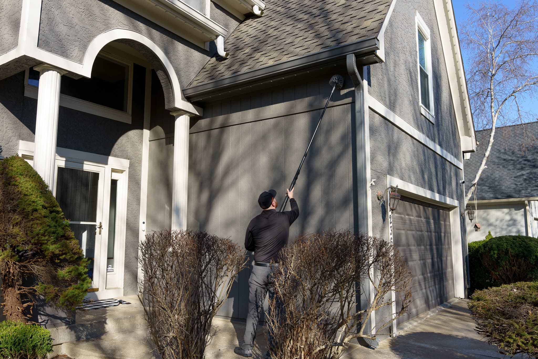 BugBros technician treating exterior of Kansas City home